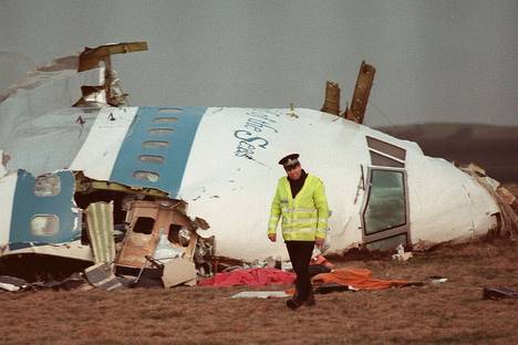 Un policier marchant devant les d�bris du cockpit du Boeing 747.AFP